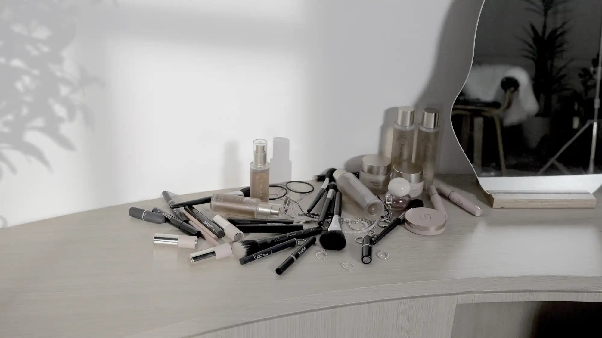 A collection of makeup and beauty products on a vanity.